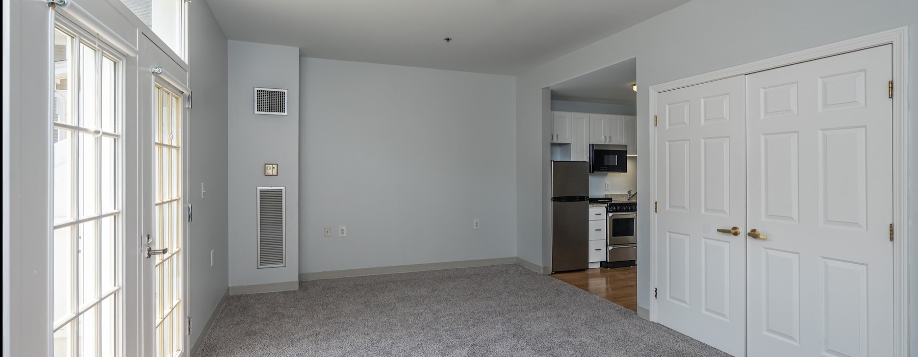 a living room with carpet and windows