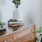 a dresser with a vase of plants on top