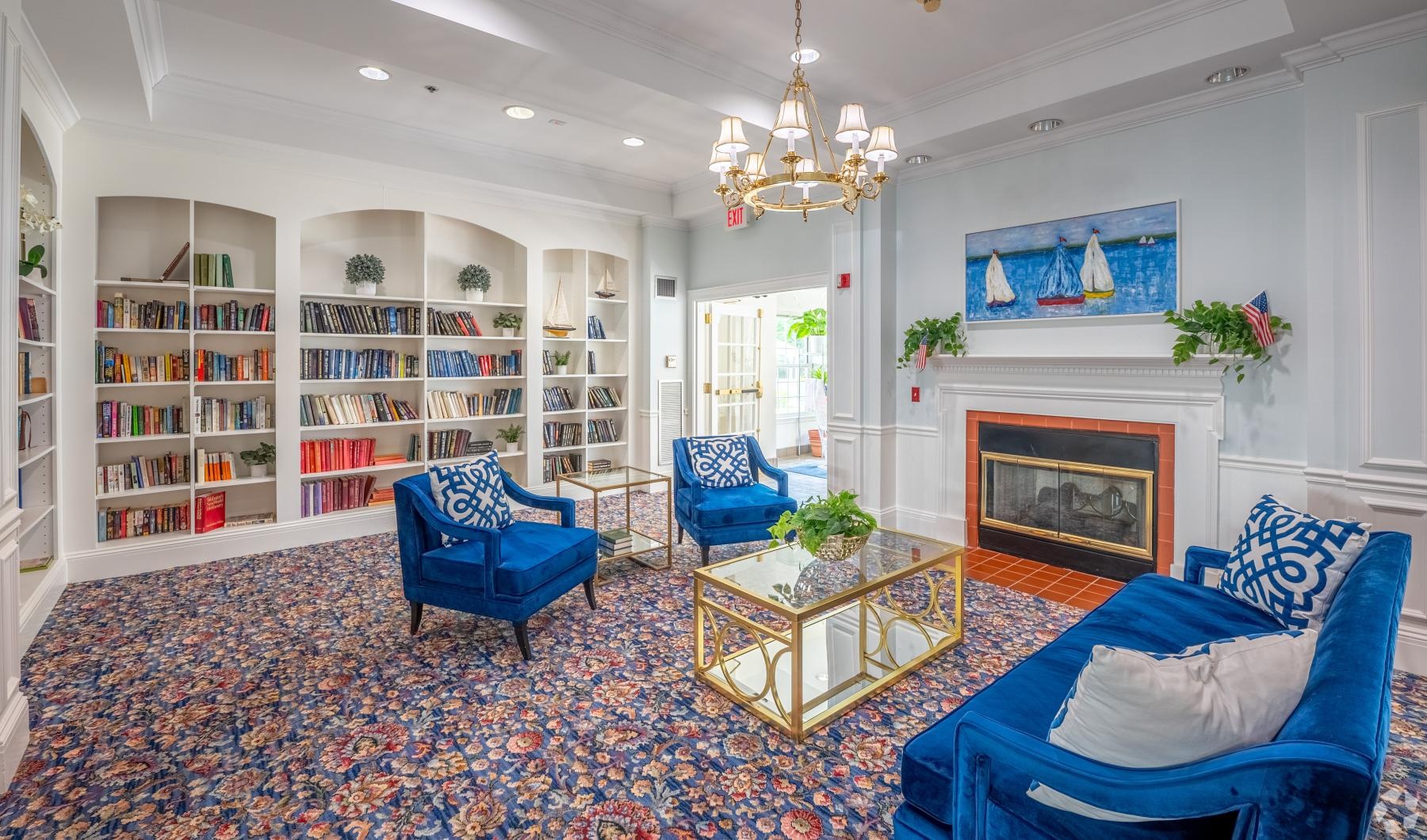 Quick access to state-of-the-art amenities a clubroom with a book case, a couch and chairs